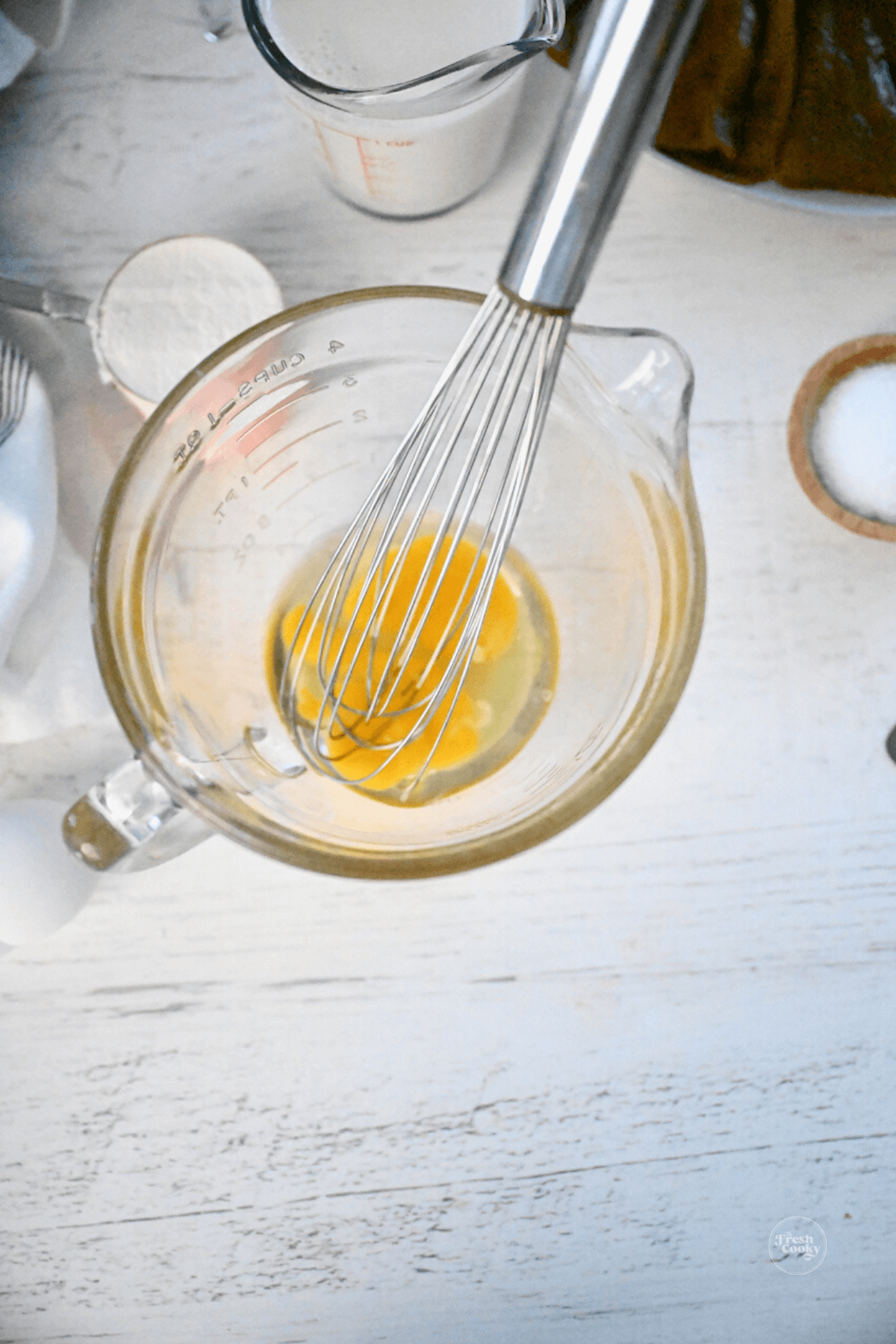 Whisking eggs in medium bowl for egg batter. 