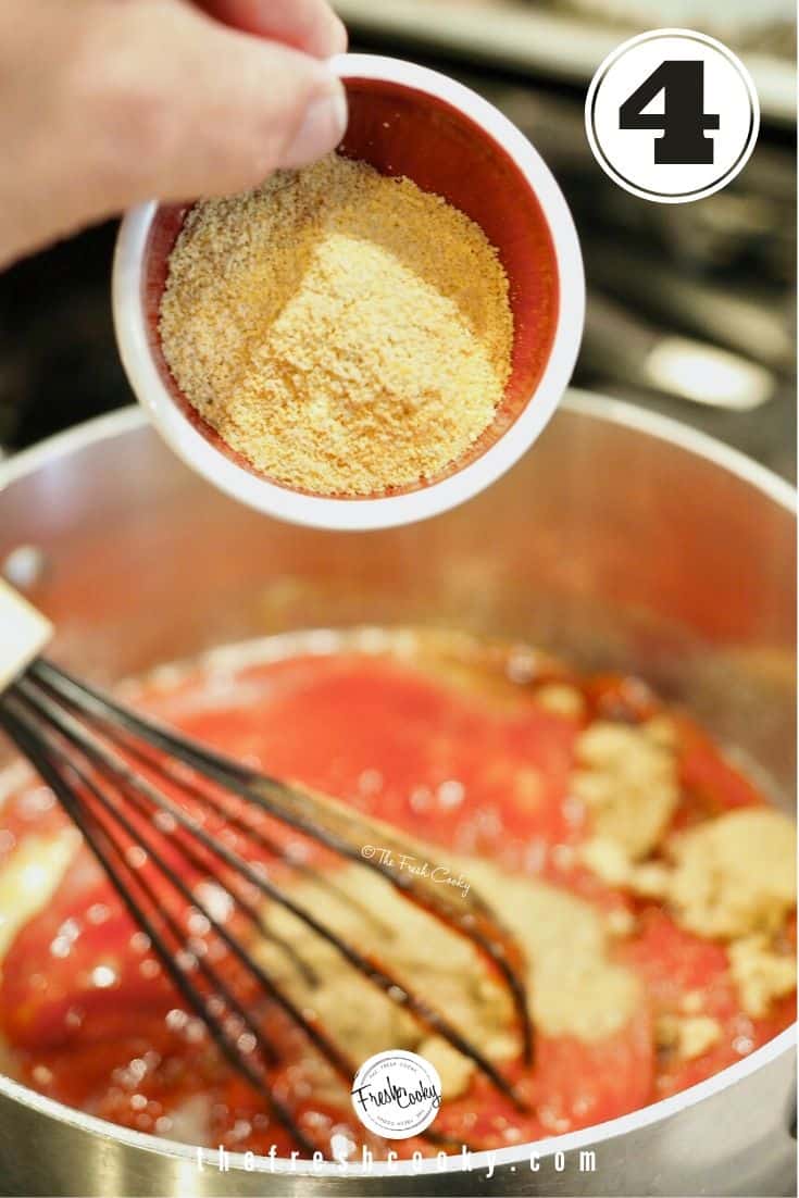 small red and white bowl with ground mustard going into pot with whisk and barbecue sauce ingredients