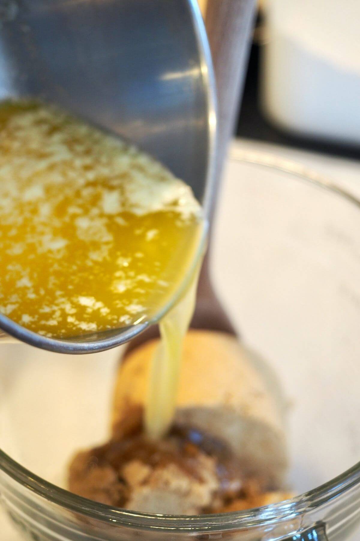Pouring melted butter over brown sugar and vanilla for blondies. 