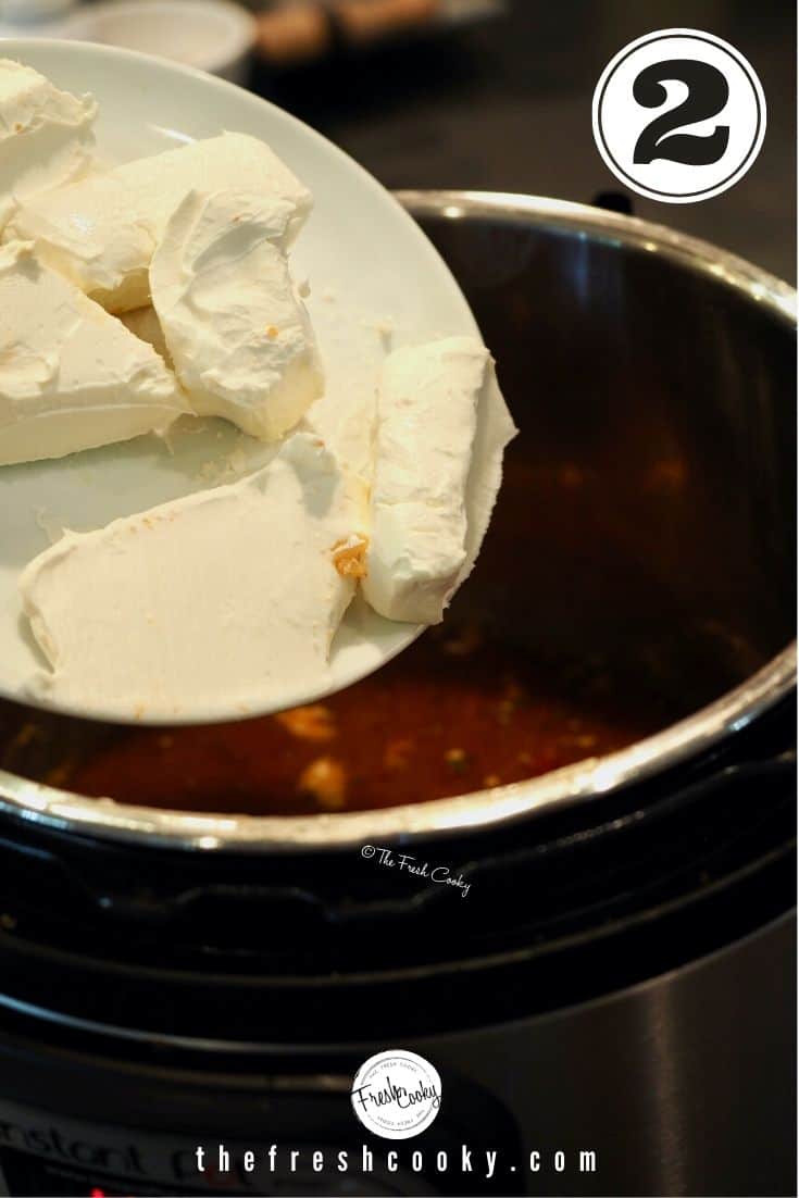 Chunks of cream cheese on white plate being put into instant pot
