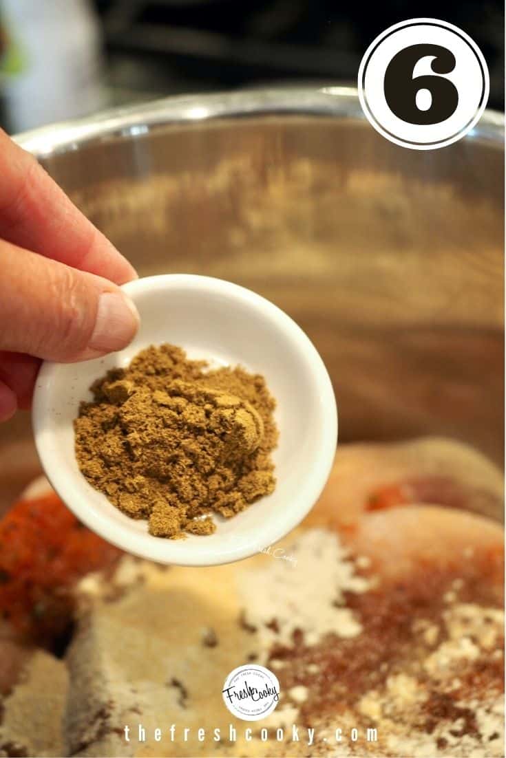 A small white bowl with cumin powder reading to pour in instant pot with chicken 