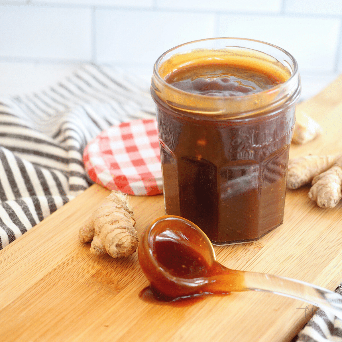 Easy Honey Teriyaki sauce recipe, with jar of sauce and glass ladle with sauce.