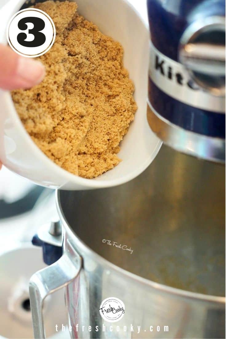 a bowl of light brown sugar being poured into mixing bowl of stand mixer