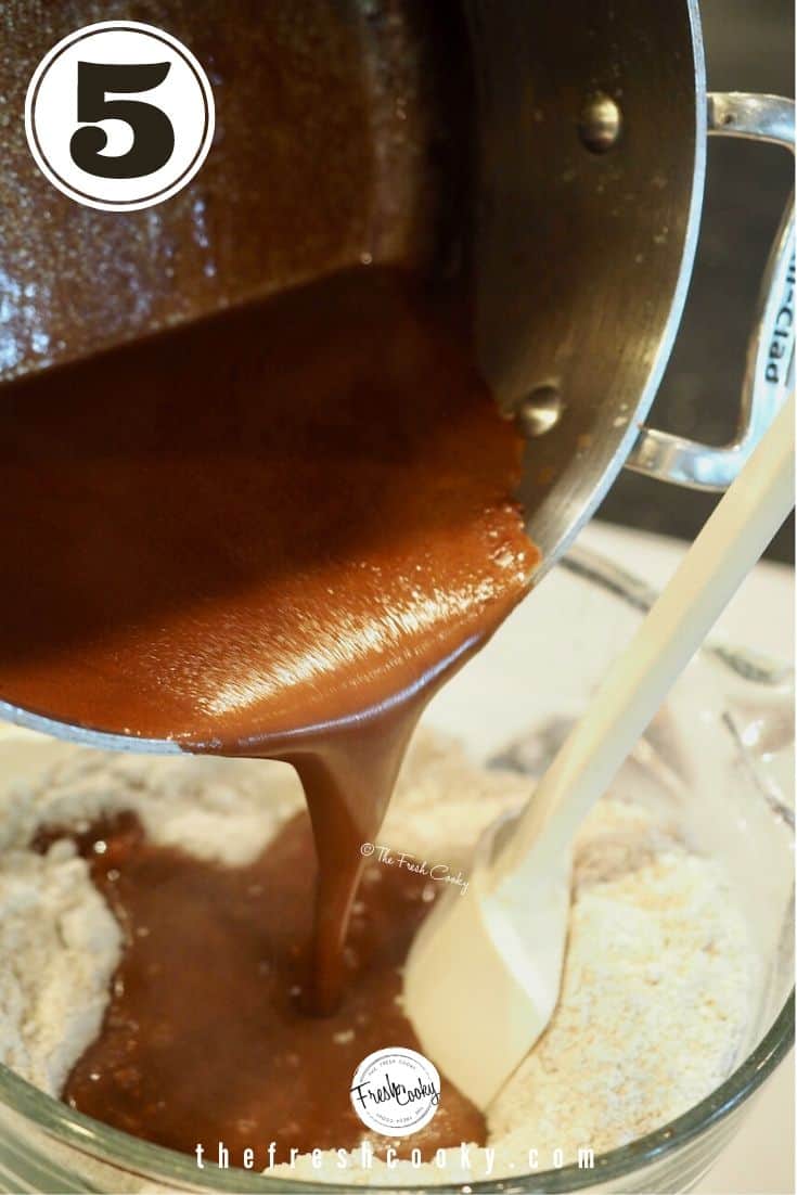 Pouring hot cocoa butter mixture into dried ingredients in large batter bowl