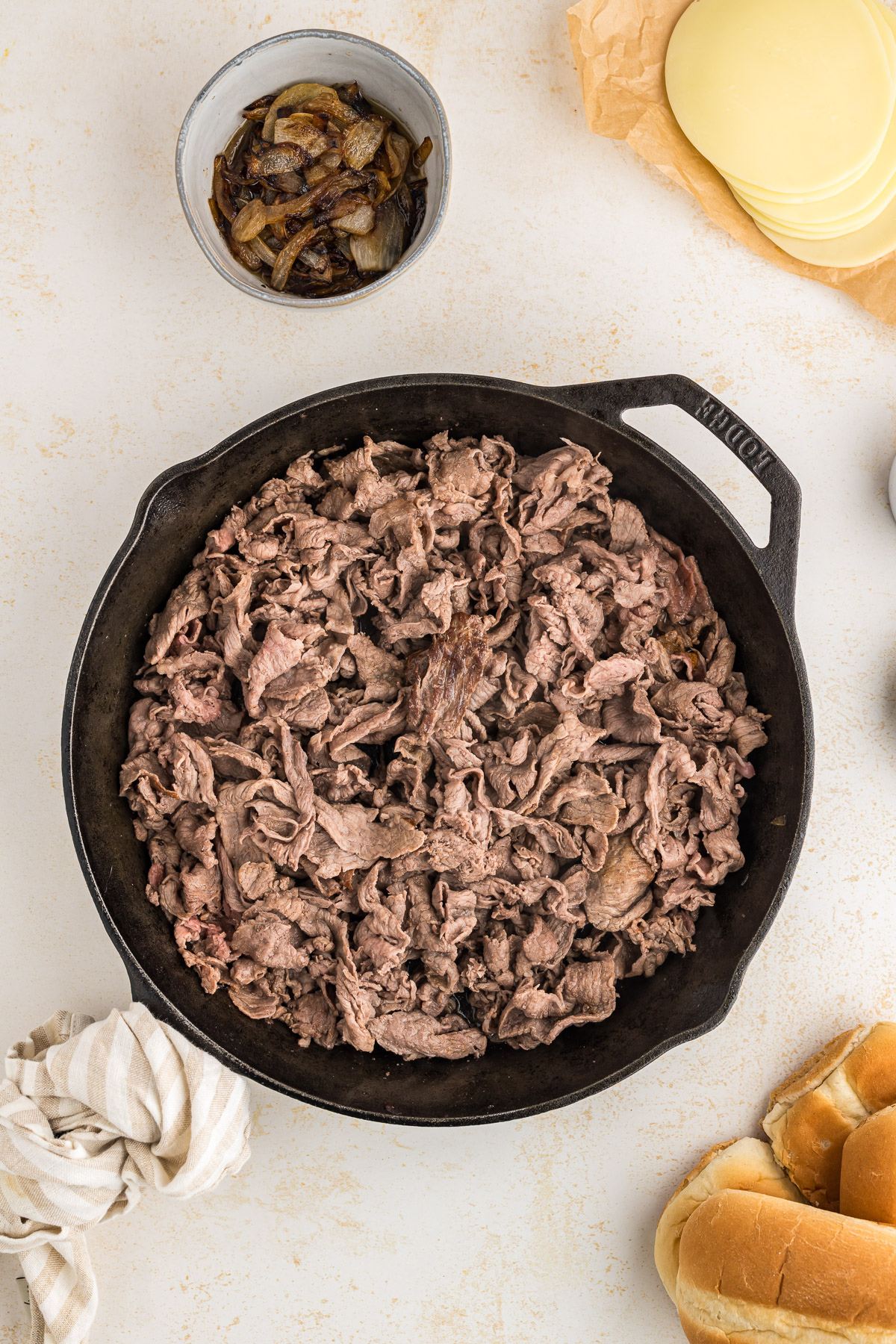 Browned shaved steak in cast iron skillet.