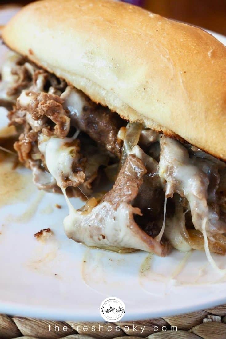 Cheesesteak sandwich oozing tender, thinly sliced beef, stringy cheese, juices and caramelized onions with a toasted sub roll.