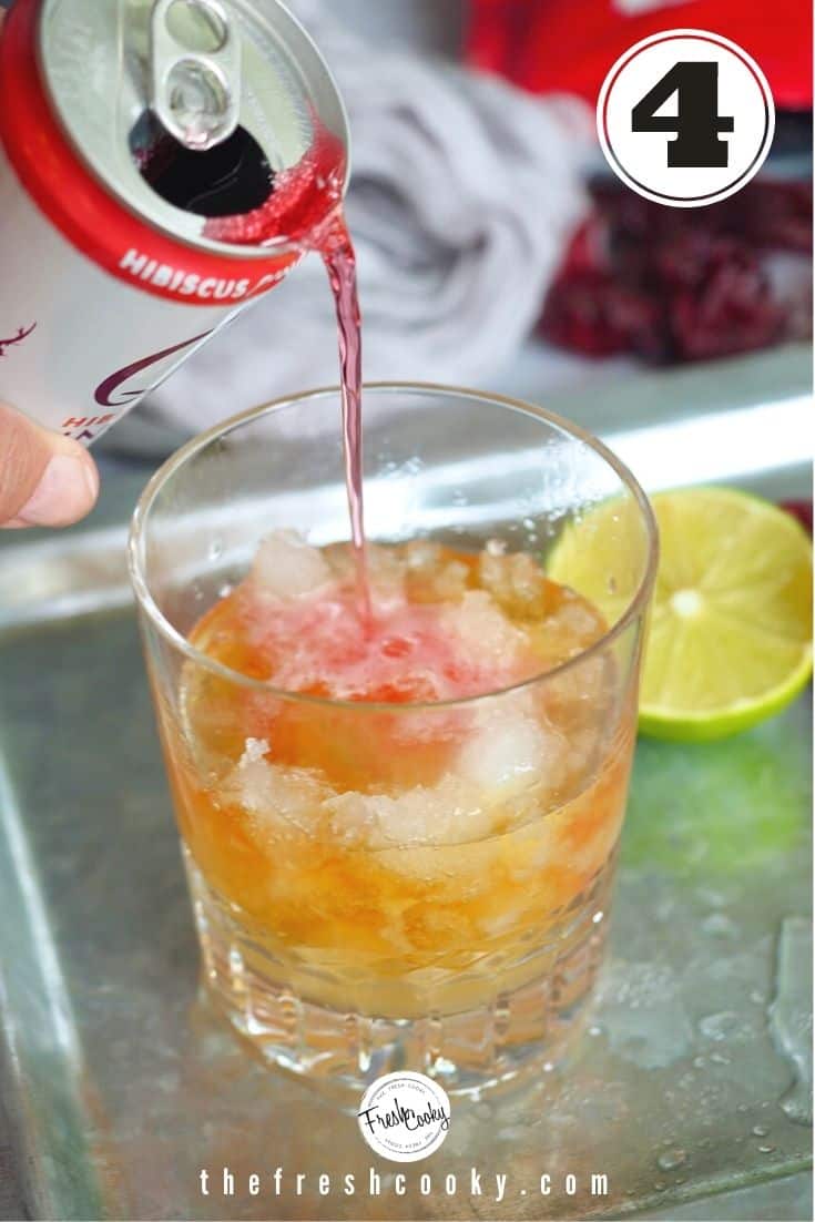 can of hibiscus ginger beer pouring into cocktail glass filled with ice, rum, lime juice. 