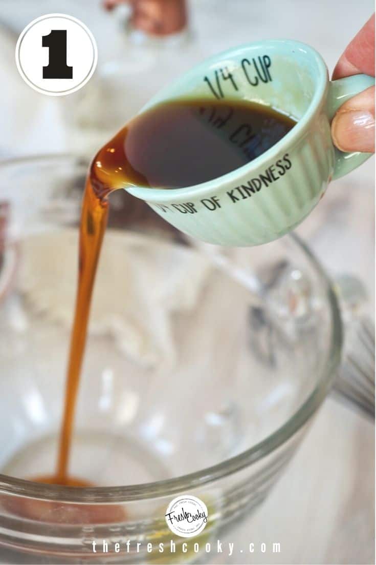 Small liquid measuring cup ¼ cup of maple syrup, pouring into glass mixing bowl