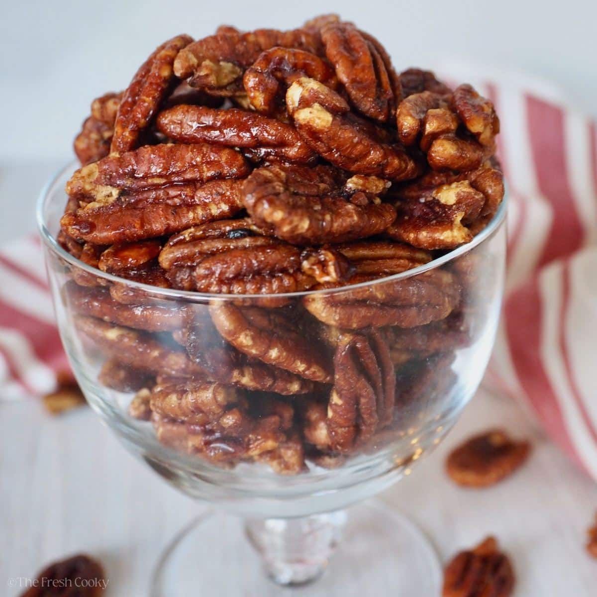 Maple Bourbon Pecans in a glass dish for snacking.