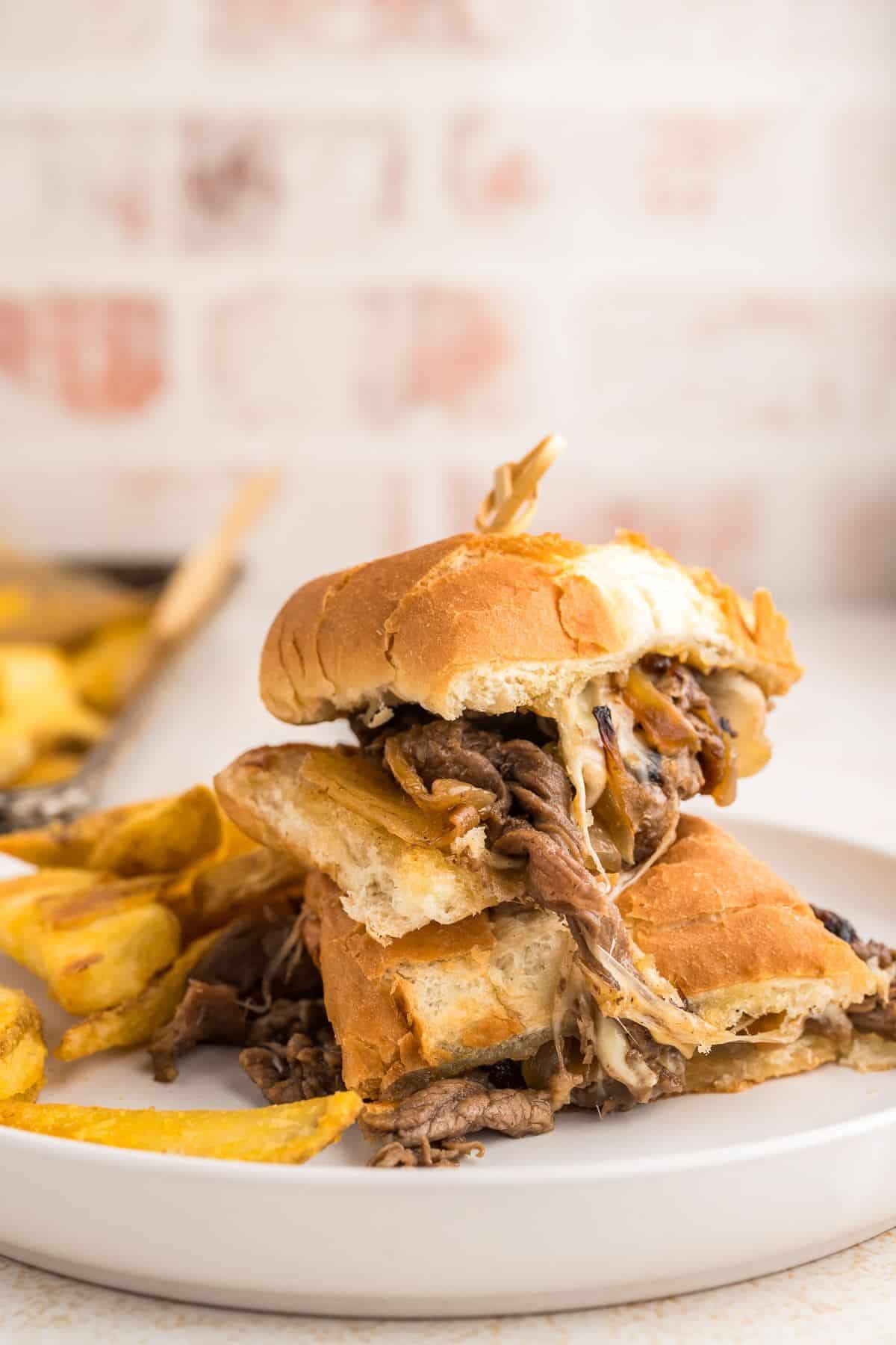 Philly steak sandwich cut in half with melty cheese and gooey tender philly cheesesteak.