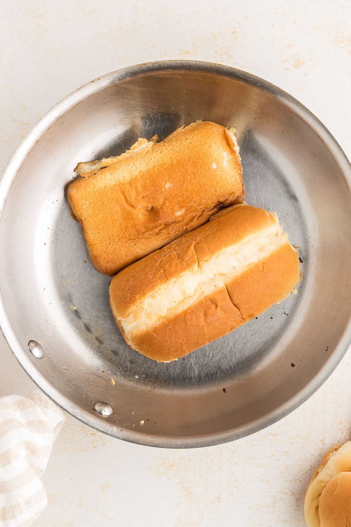 Toasting the hoagie rolls in pan with butter. 