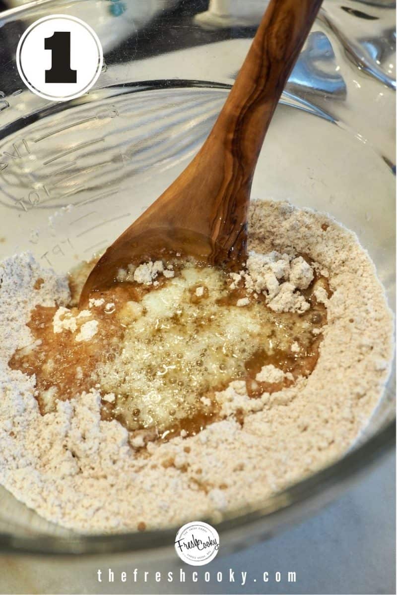 Streusel Crumb mixture with melted butter and vanilla in glass mixing bowl with wooden mixing spoon