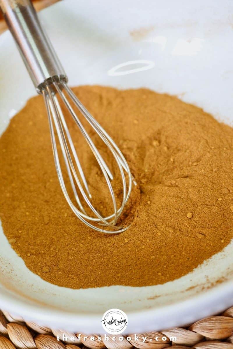 Pumpkin Pie Spice mixture all mixed in white bowl with mini wire whisk