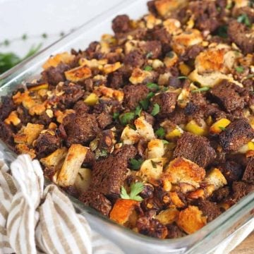 Image of casserole dish filled with the best stuffing ever, a variety of bread types are used with chunks of sausage, nuts, apples and more