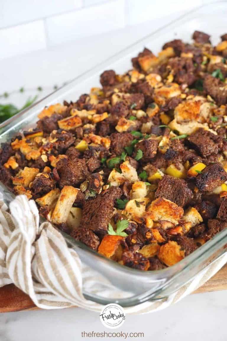 Image of casserole dish filled with the best stuffing ever, a variety of bread types are used with chunks of sausage, nuts, apples and more