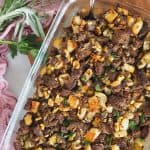 Flat lay image of thanksgiving stuffing with napkin in back ground and fresh herbs