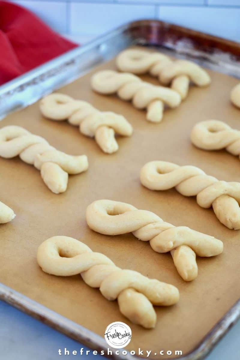 prepped uncooked Greek Butter Cookie Twists on parchment lined baking sheet.