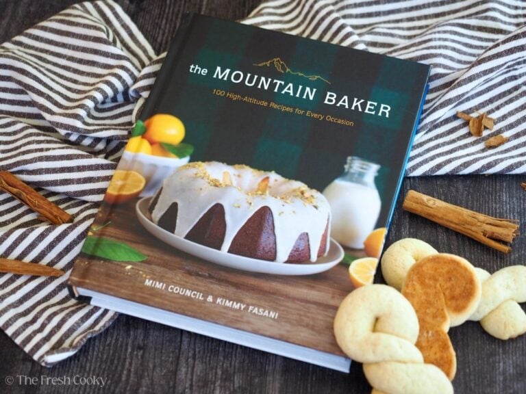 Image of a copy of The Mountain Baker cookbook, with Greek twisted cookies laying nearby.