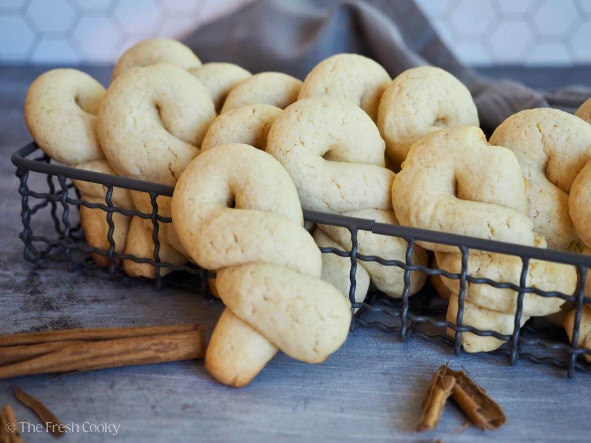 Twisted Greek butter cookies in a wire basket.