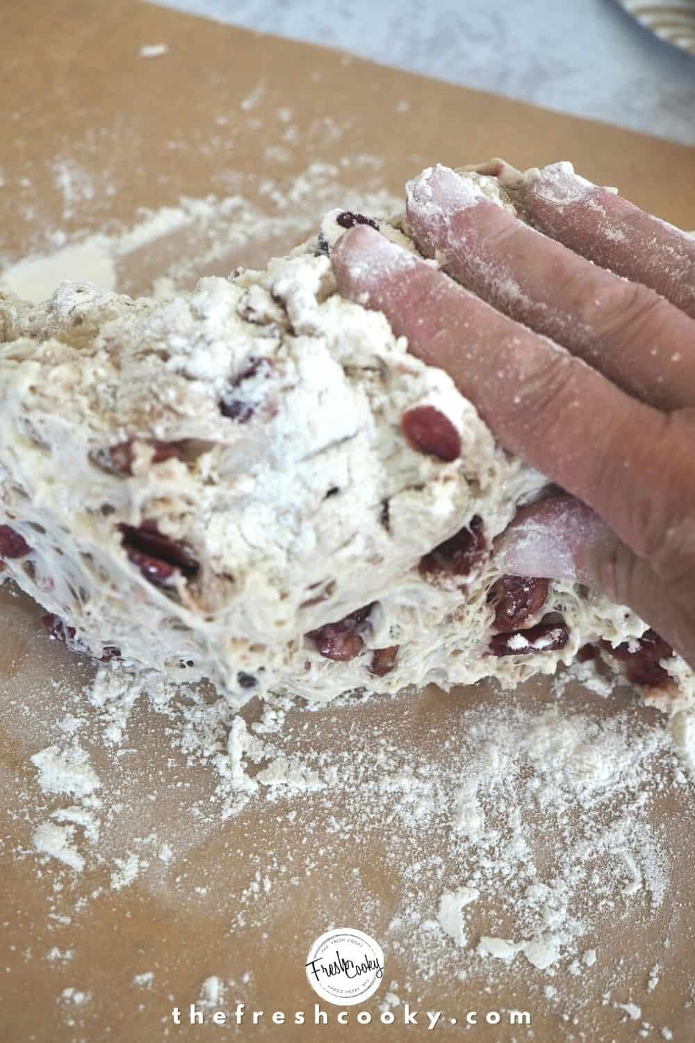 Gentle shaping dough with floured hands on parchment paper.