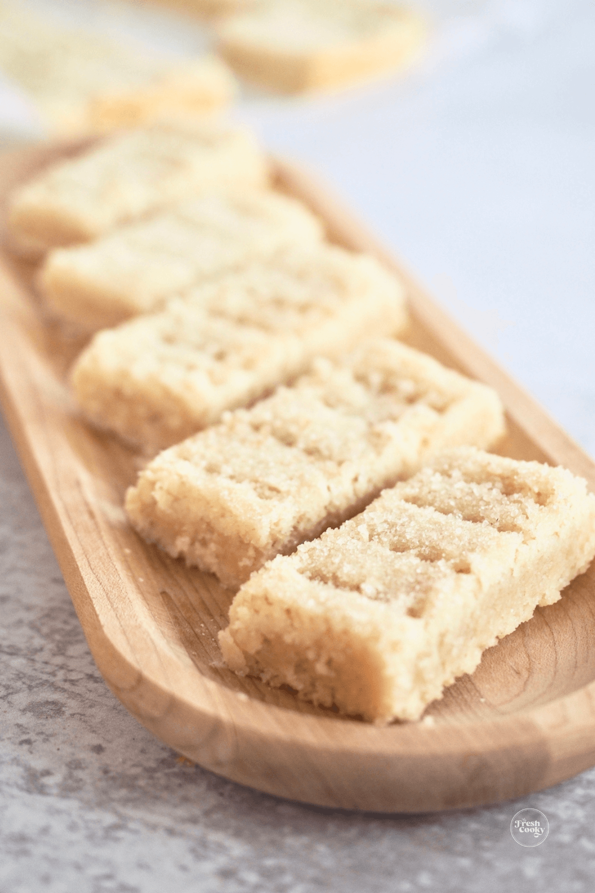 Fingers of shortbread cookies on a wooden tray for serving.