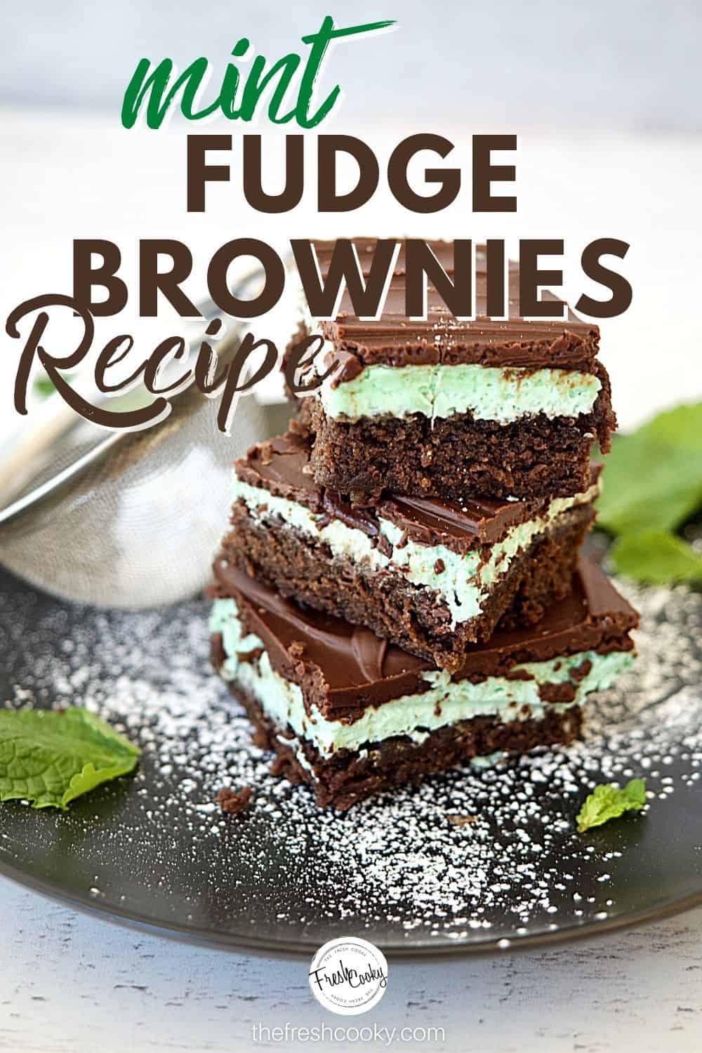 Pinterest Image for Mint Fudge Brownie recipe with three stacked fudge layered brownies on a black plate with powdered sugar sprinkled and mint leaves on plate.