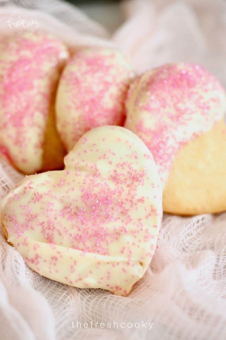 Heart Shaped Scottish Shortbread cookies dipped in white chocolate with light pink sprinkles.