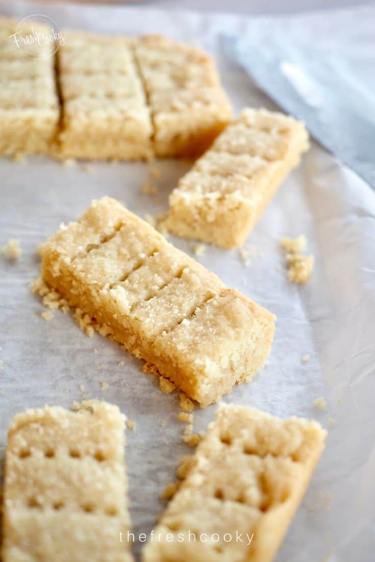 Shortbread fingers sliced and sitting askew on parchment paper