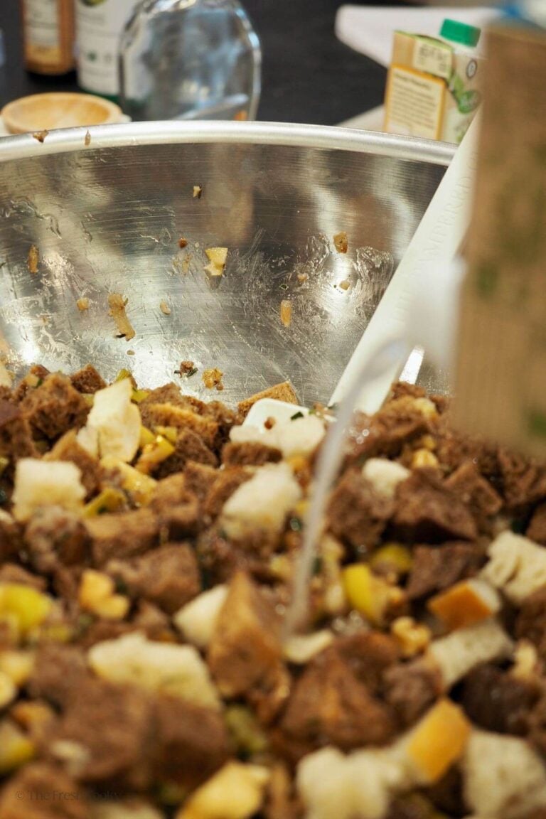 Pouring broth into stuffing and mixing.