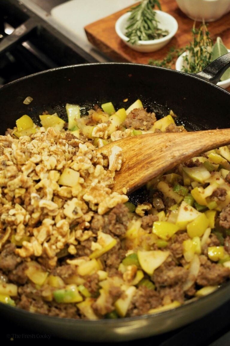 Stirring in walnuts into meat and veggie mixture.