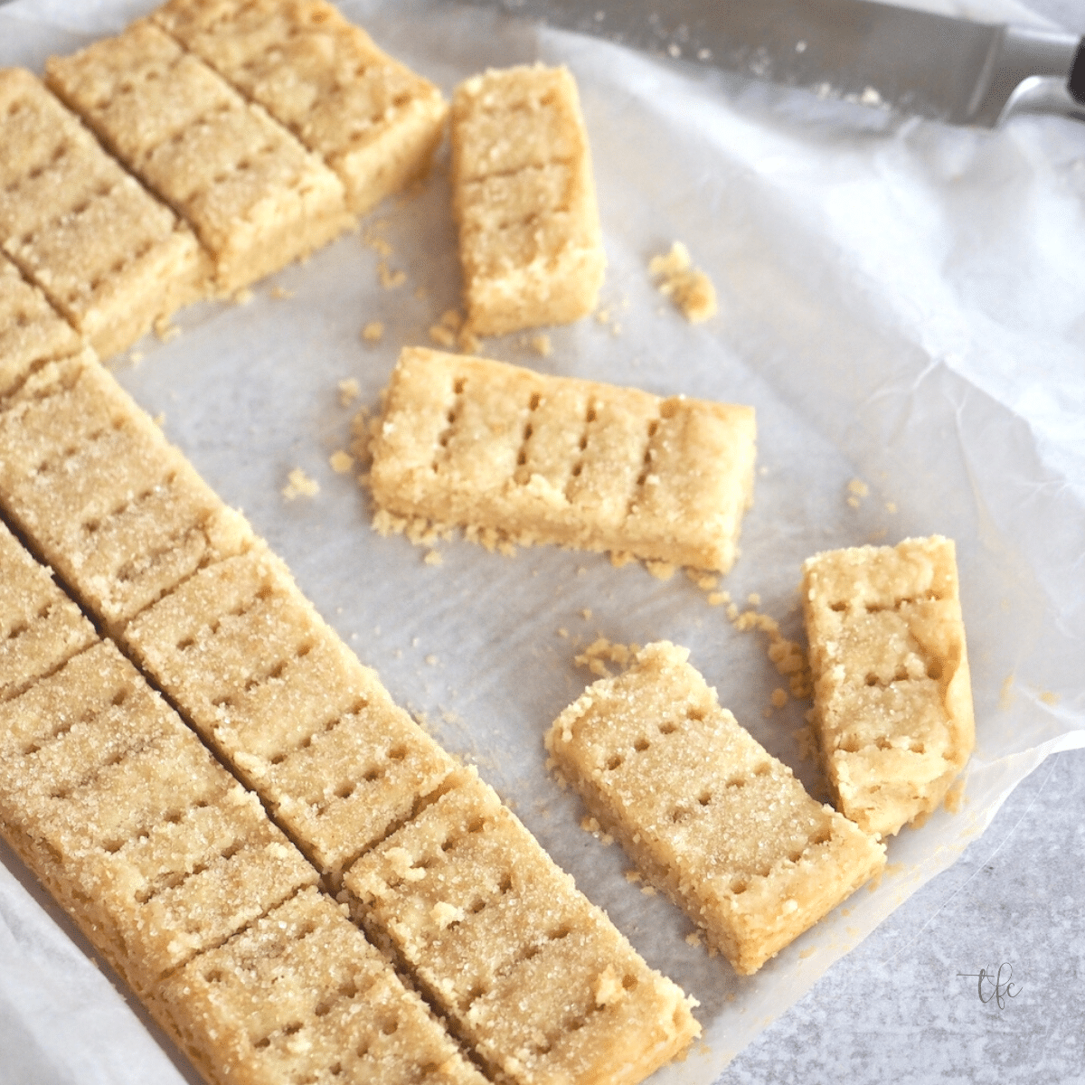 Traditional shortbread cookies biscuits on parchment paper, sliced into finger bars.