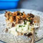 Turkey Divan with stuffing topping on top, image of slice of divan on plate with a fork.