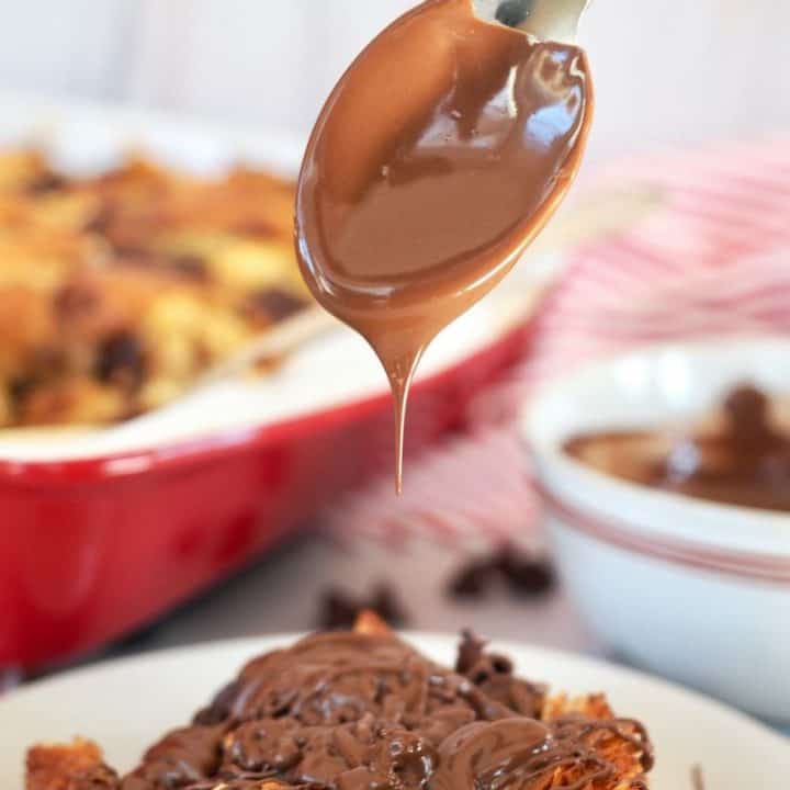 Square of Chocolate Chip Croissant French Toast with spoon drizzling nutella on top