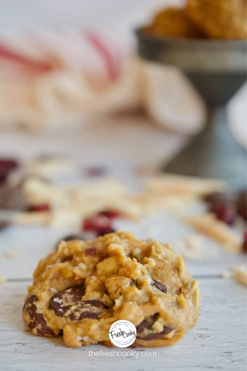 Best Gluten Free Breakfast Cookies image with single cookie in foreground, cranberries, almonds and chocolate chips in background.