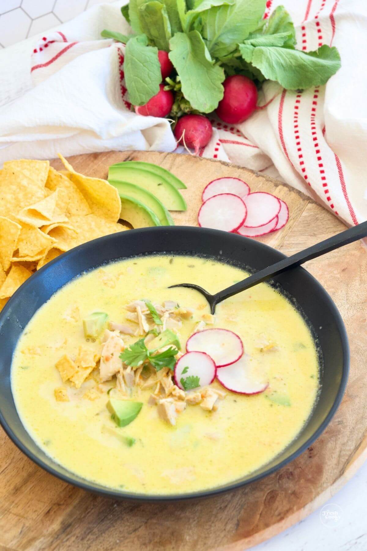 Large black soup bowl filled with chicken poblano soup.