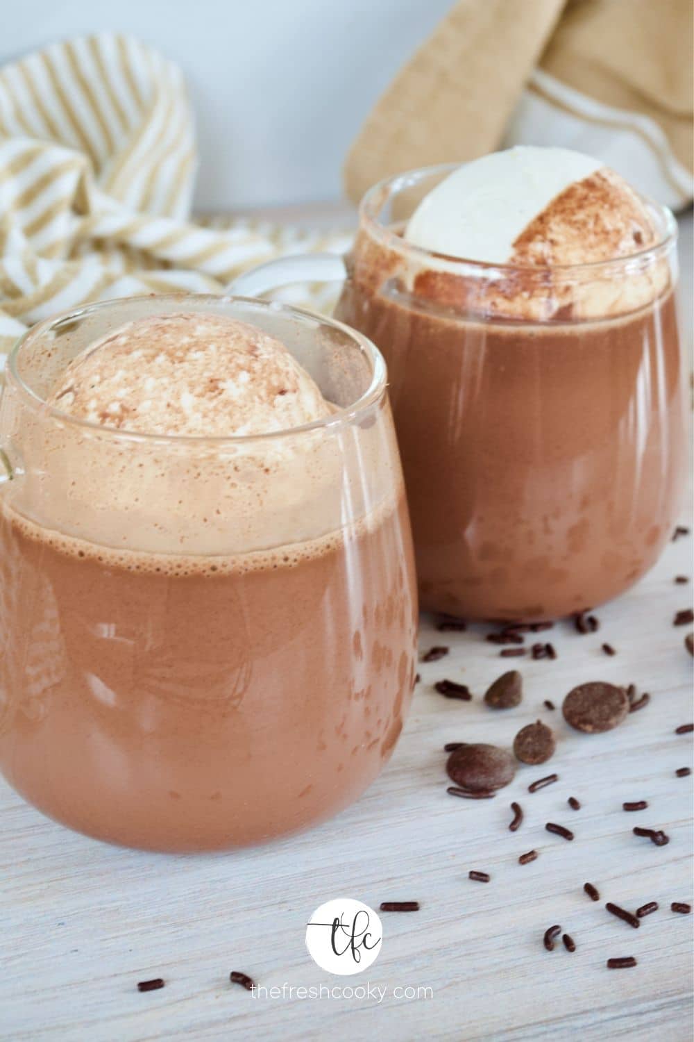 Hero image for Homemade Hot Chocolate in glass mugs with large spheres of whipped cream.