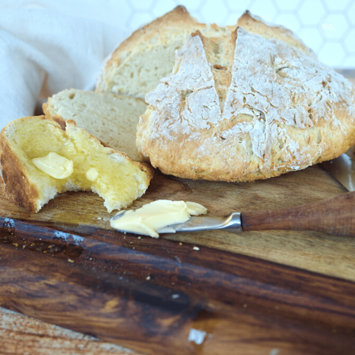Irish soda bread with wedge removed, buttered with Irish butter.