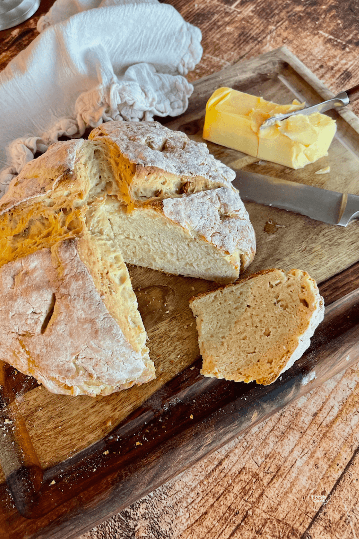 Irish soda bread on cutting board with wedge removed.