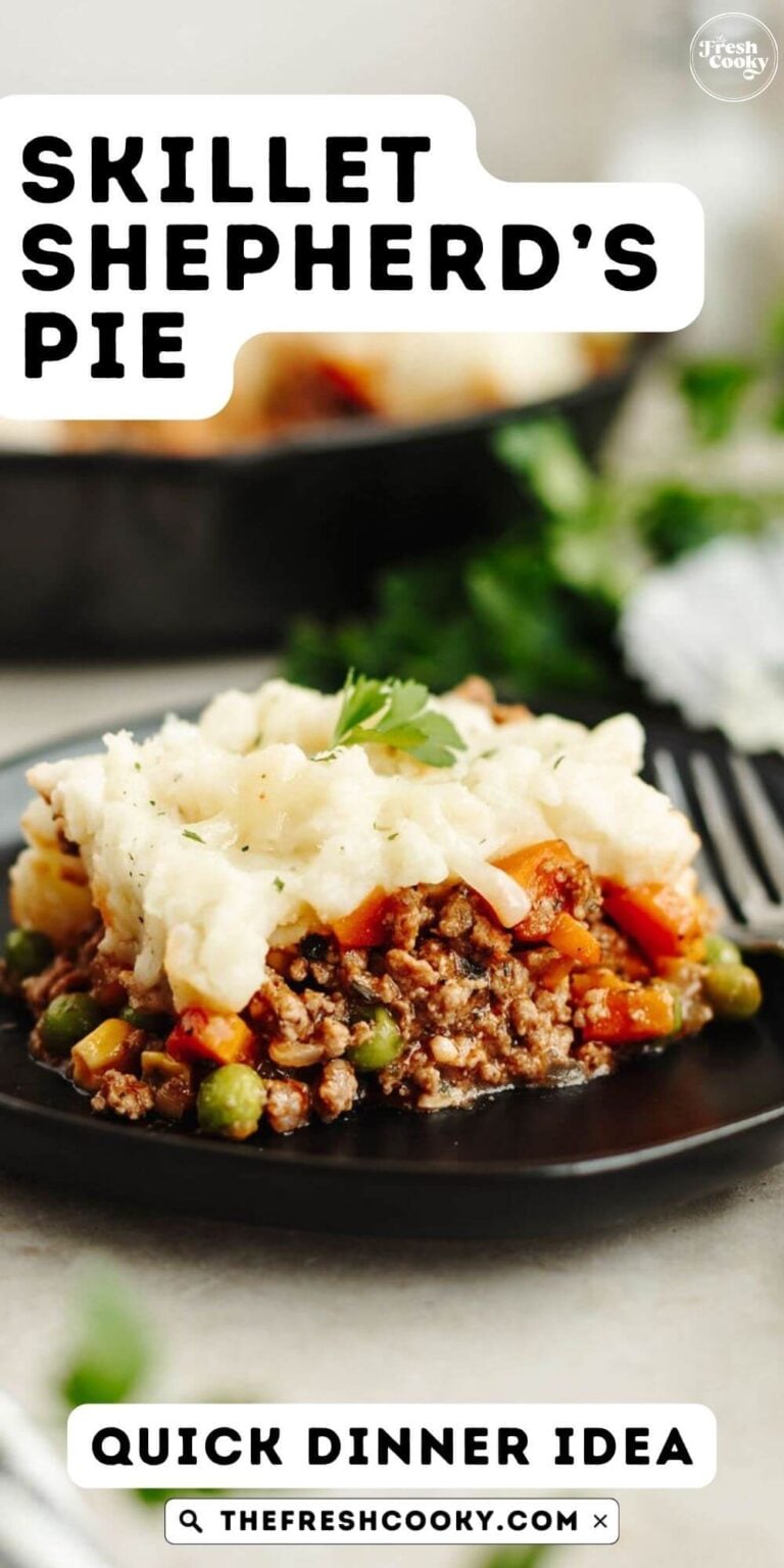 A slice of meaty shepherd's pie on a black plate with a fork, topped with mashed potatoes, to pin.