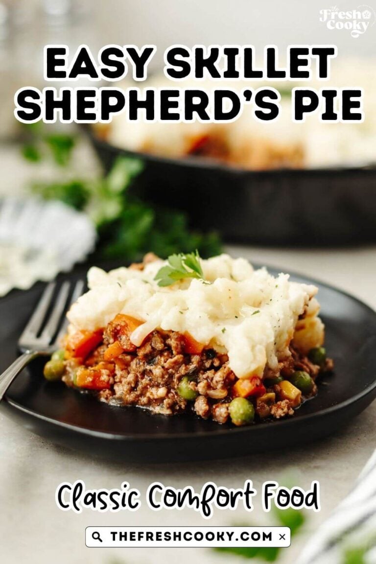 A cast iron skillet in background, with a serving of Shepherd's pie in foreground, topped with mashed potatoes, to pin.