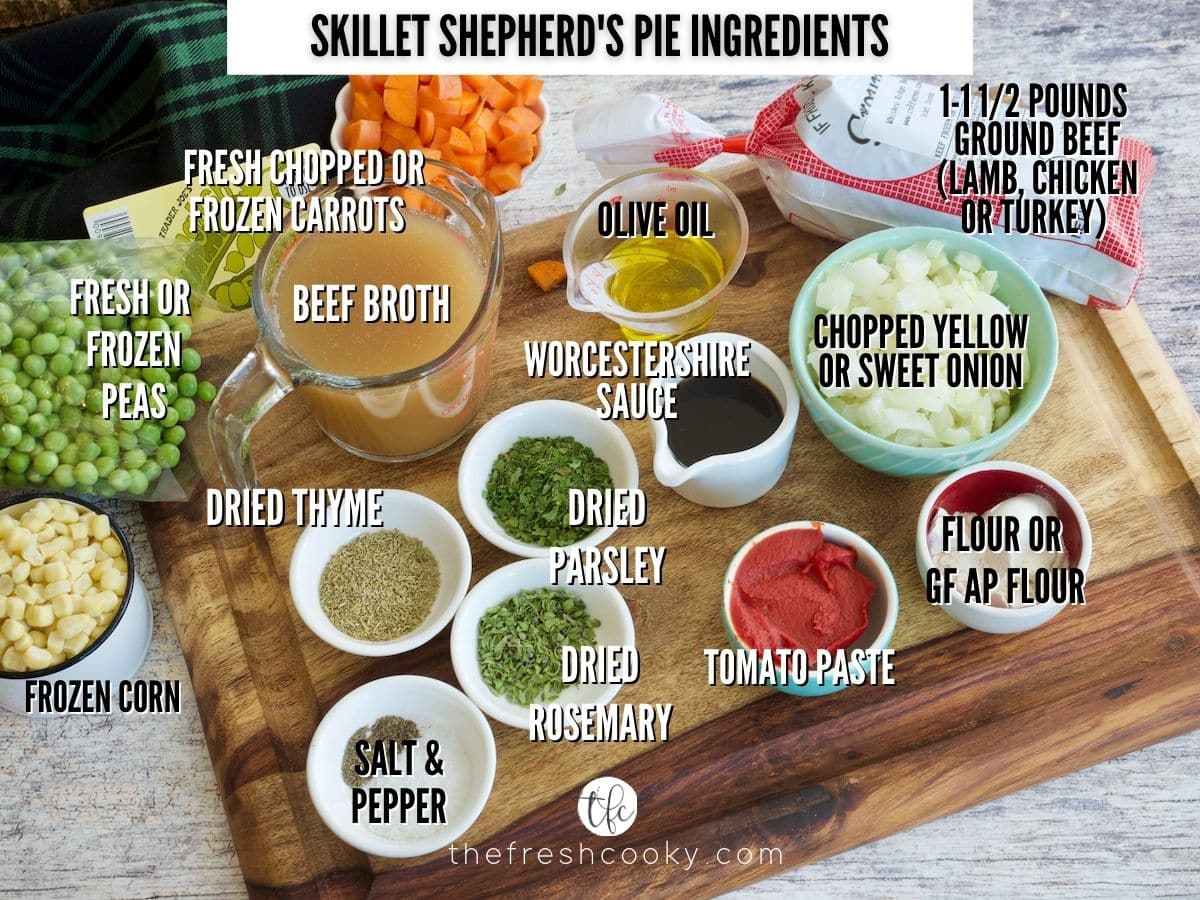 Ingredient shot for Skillet Shepherd's Pie. L-R frozen corn, peas, beef broth, carrots, ground beef, oil, onions, flour, tomato paste, worcestershire sauce, parsley, thyme, rosemary, salt and pepper, garlic (not shown).