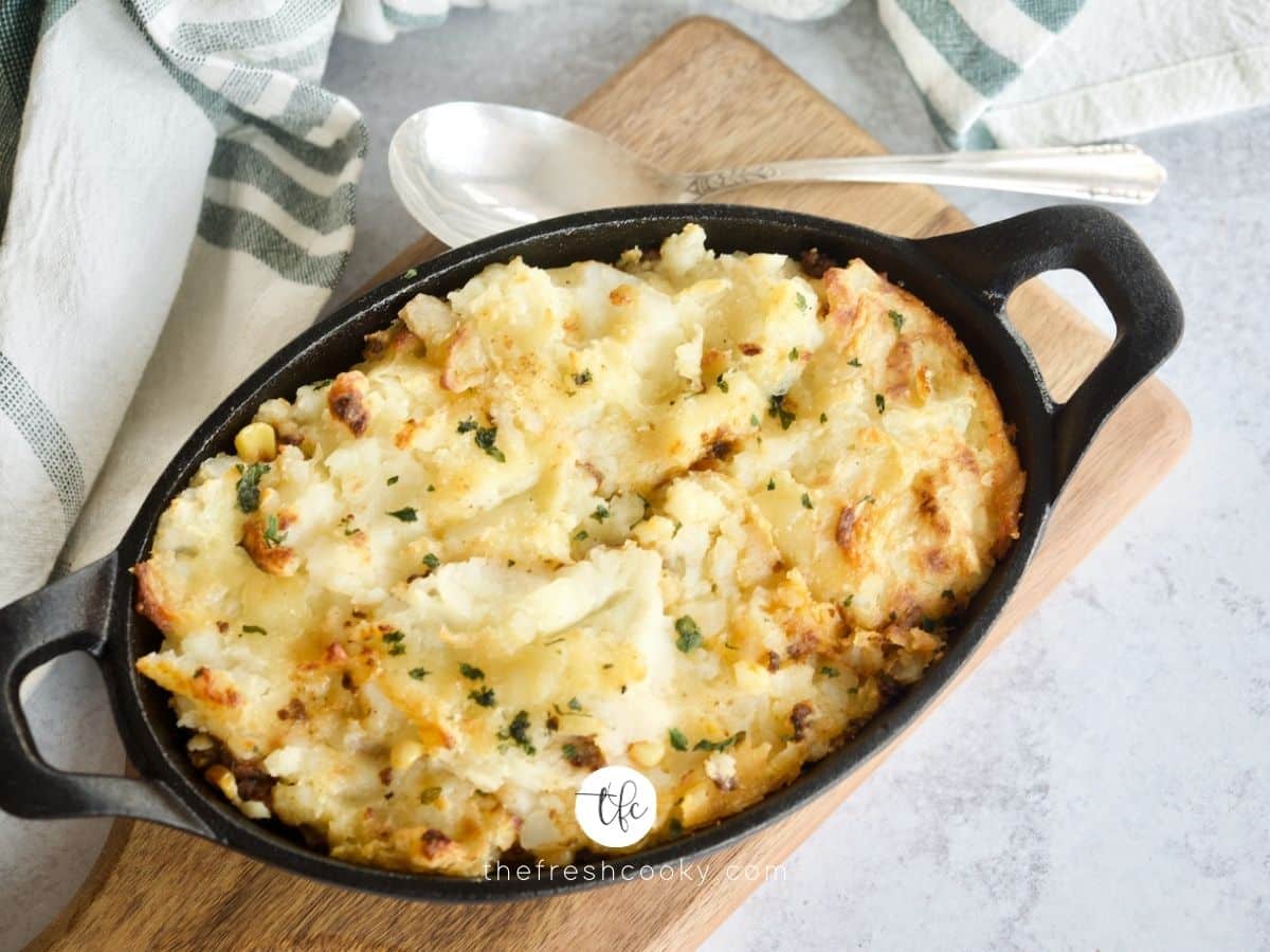 Top down shot of small skillet filled with Shepherd's pie topped with creamy mashed potatoes.