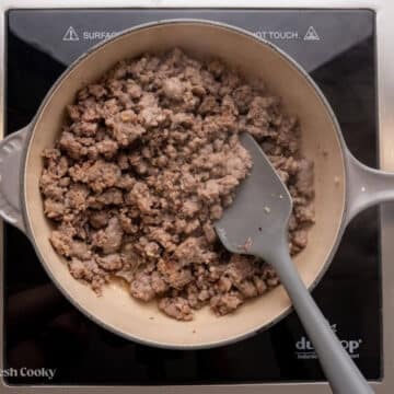 Brown the sausage in a skillet.