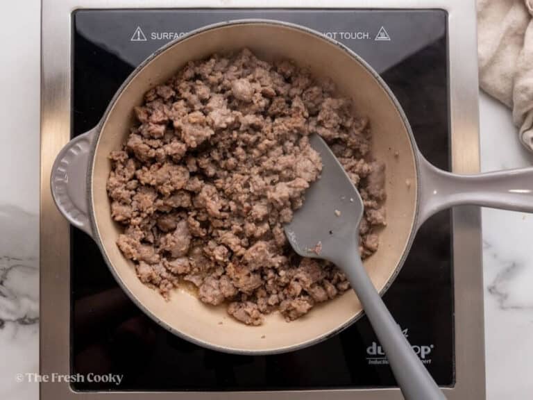 Brown the sausage in a skillet.