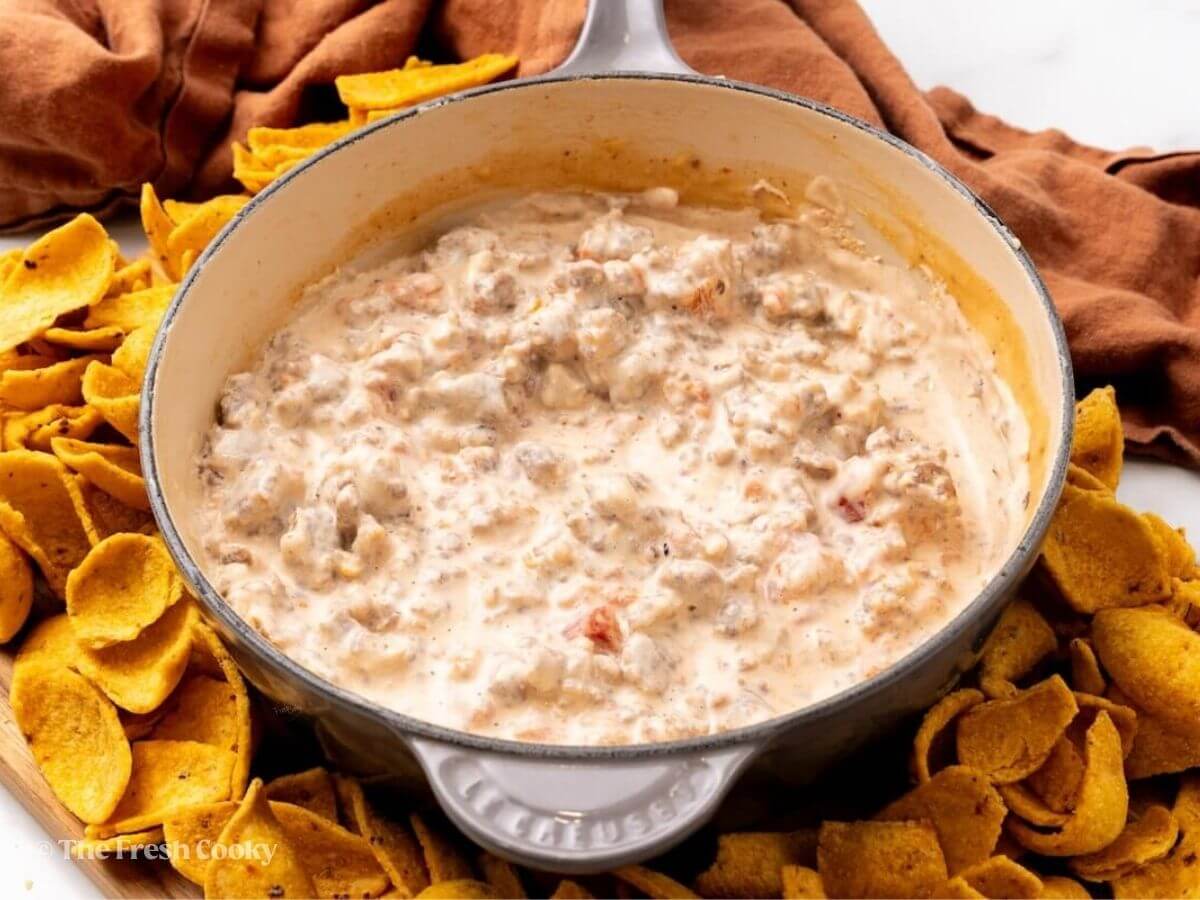 Sausage dip in skillet surround by Fritos chips.