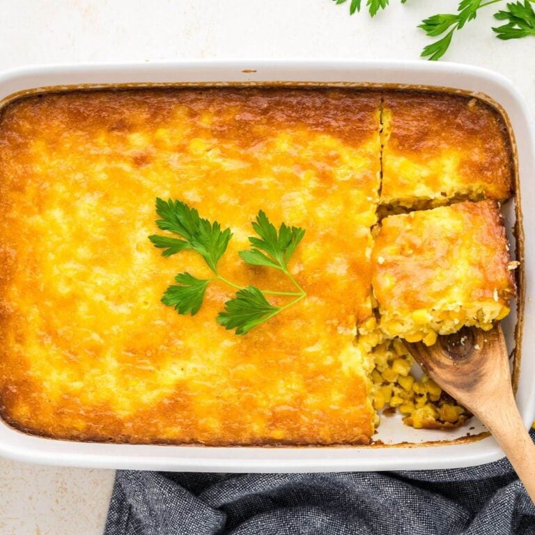 Spatula taking out slice of corn pudding casserole.