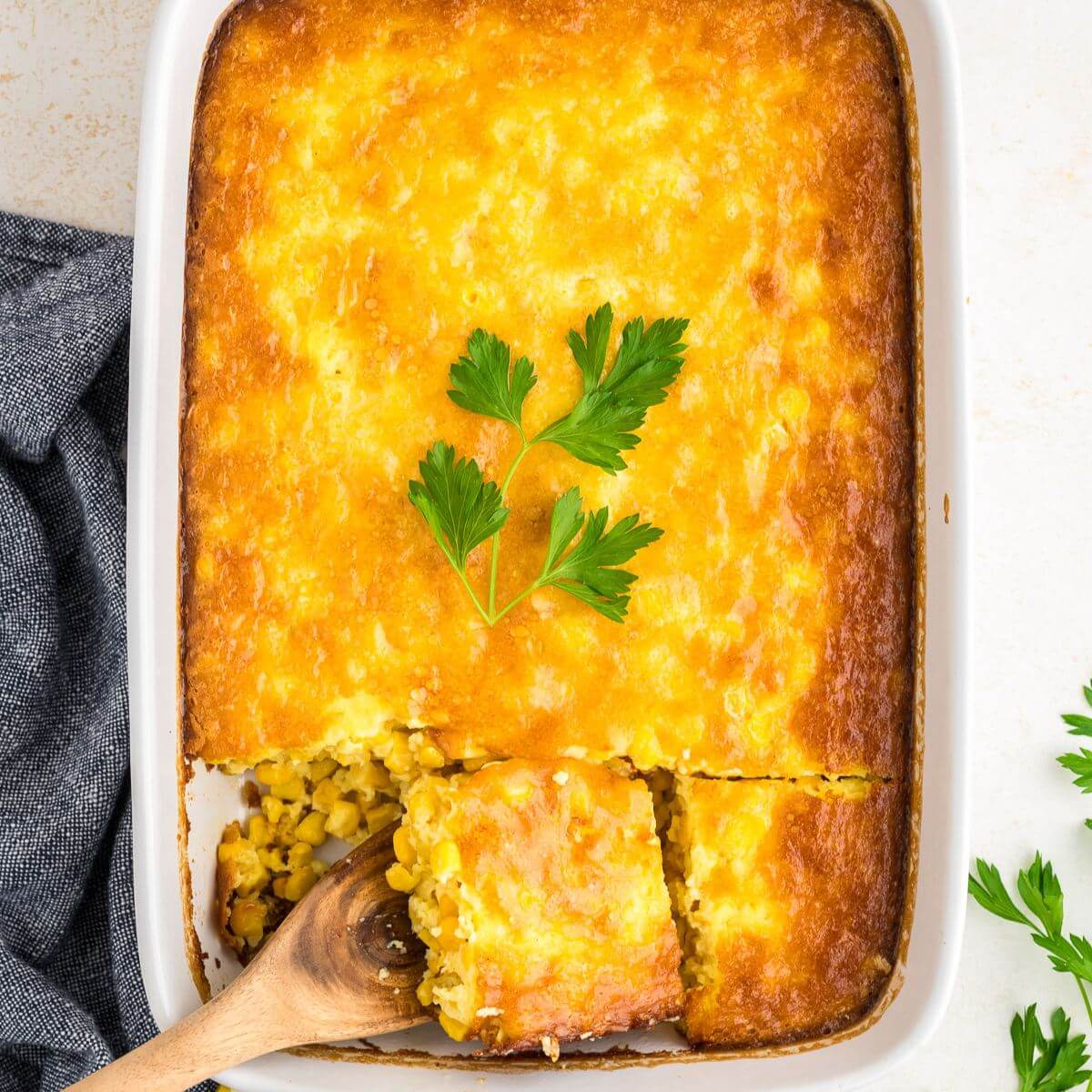 Spatula taking out slice of corn pudding casserole.