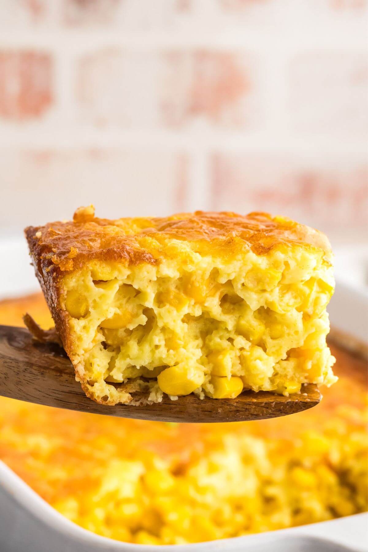 Slice of corn pudding on a serving spatula.