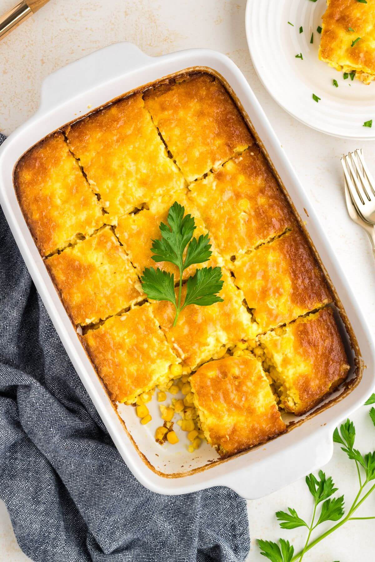 Best corn pudding casserole in dish with corn pudding sliced.