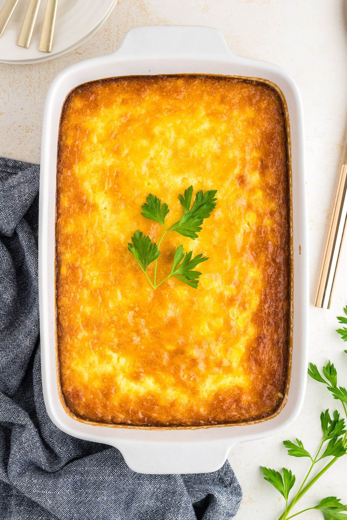 Baked corn pudding without creamed corn in casserole dish. 
